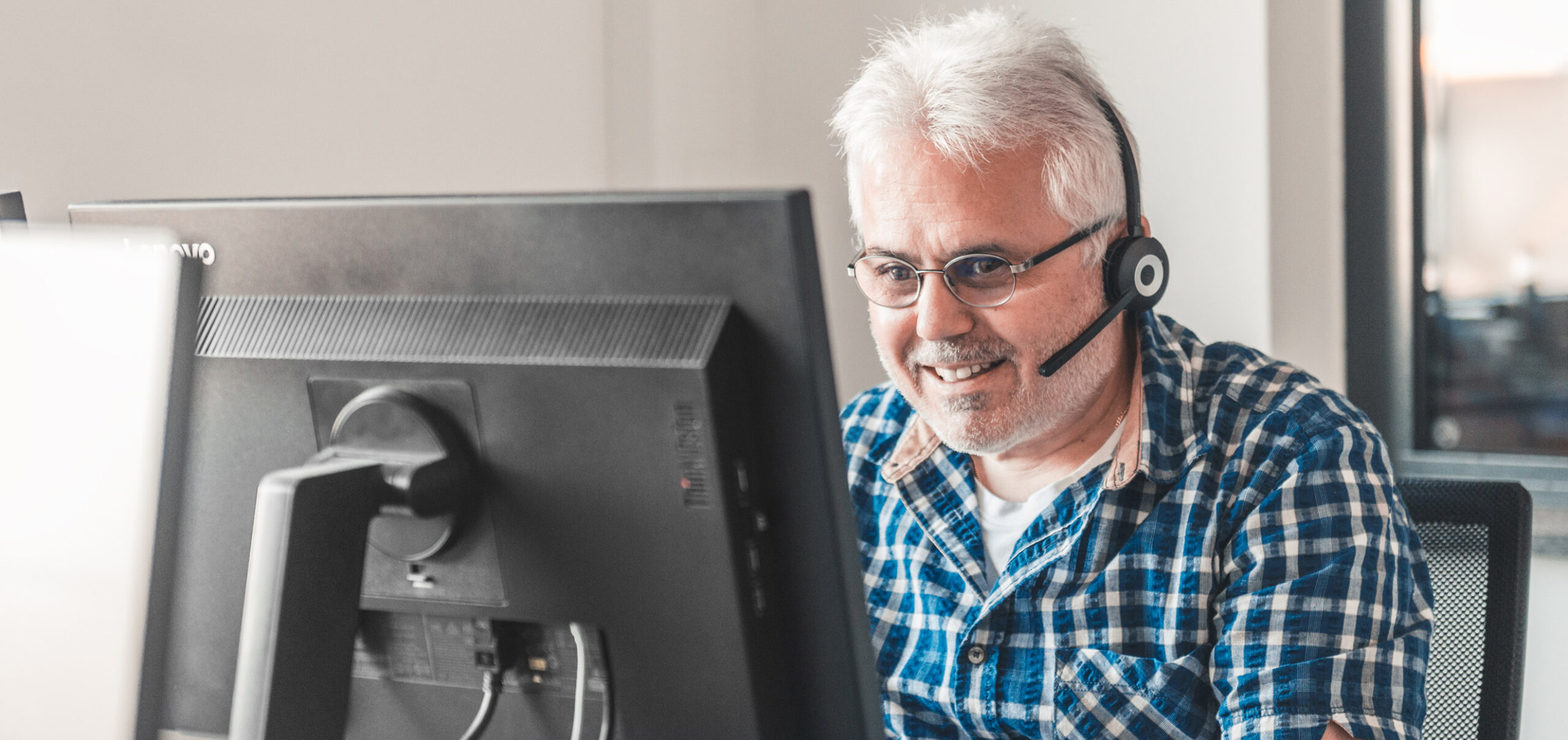 Mitarbeiter am PC mit Headset